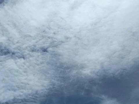The sky is cloudy with altocumulus clouds and the sun peeking through them_02 Stock Photos