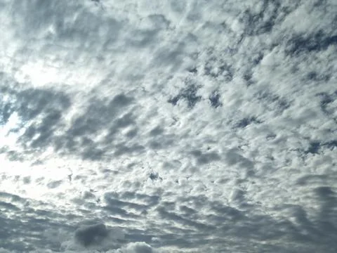 The sky is cloudy with altocumulus clouds and the sun peeking through them_03 Stock Photos