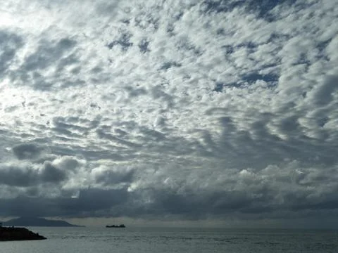 The sky is cloudy with altocumulus clouds and the sun peeking through them_04 Stock Photos