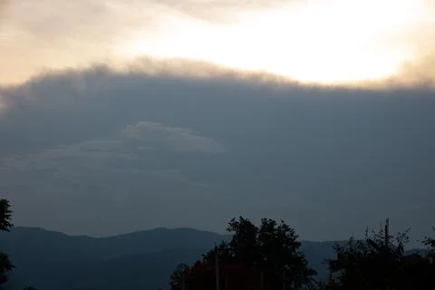The sky is cloudy and the sun is setting Stock Photos