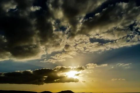 The sky is cloudy and the sun is setting Stock Photos
