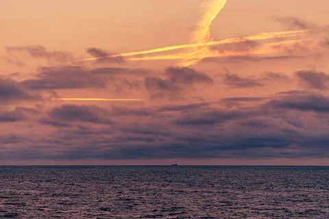 The sky is cloudy, casting a grey hue over the vast expanse of water Stock Photos