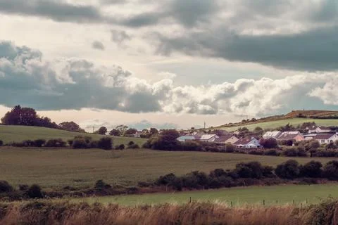 Sky with cumulus clouds over a small Irish village on a summer evening. Stock Photos