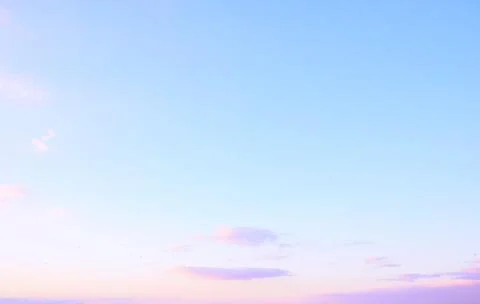 Sky at dawn showcasing a soft gradient of blue and pink hues over a peaceful Stock Photos