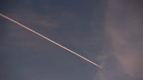 Sky at dusk with plane and contrails - Pan with Plane Stock Footage 89944678