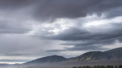 Sky with evening clouds over mountain ridge in fall Stock Photos