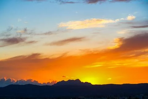 The sky is filled with clouds and the sun is setting Stock Photos