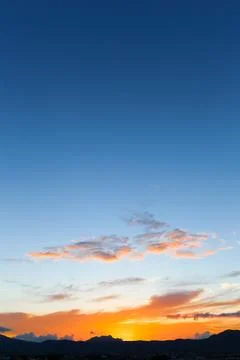 The sky is filled with clouds and the sun is setting Stock Photos