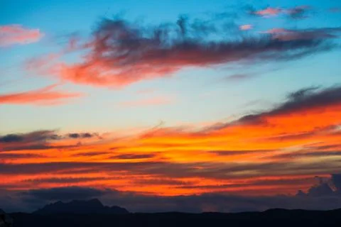 The sky is filled with clouds and the sun is setting Stock Photos