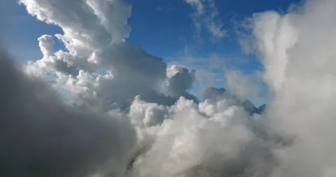 A sky filled with fluffy white cumulus clouds over a natural landscape Stockbeeldmateriaal 274145509