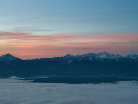 The sky is filled with orange, half of it is blue and there is a very thick whit Foto stock