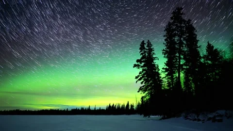 Sky filled with star trails and Northern Lights above a frozen lake Stock Footage 169355086