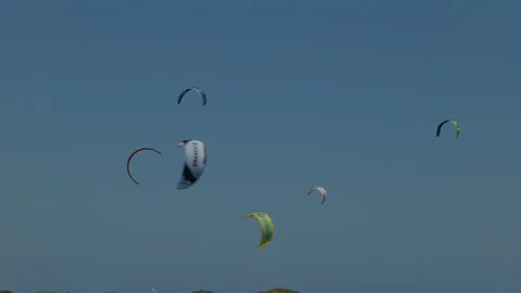The sky is filled with swirling kite sails with glimpses of the surfers beneath Stock Footage 229459632