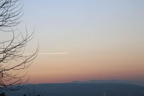 Sky on fire during sunset with a trace of plane. Stock Photos