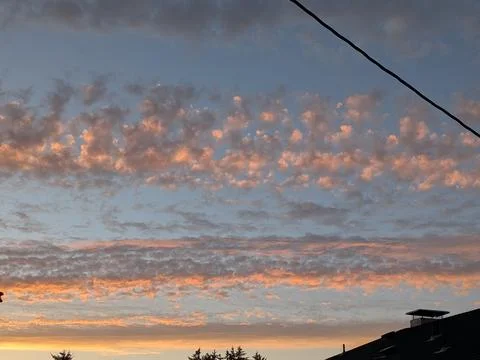 Sky full of round puffy clouds illuminated by soft orange and blue tones Stock Photos