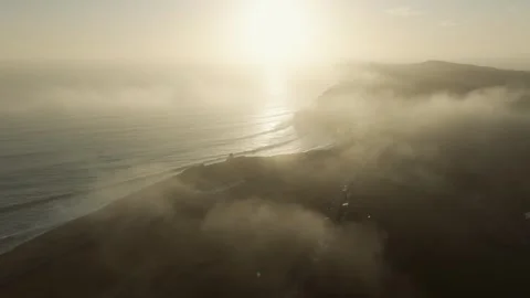 The sky is hazy and the sun is setting over the ocean Video stock 303710137