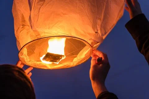 Sky Lantern being released into the night sky to wish for good luck. Stock Photos
