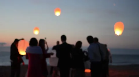 Sky lantern flying in night sky. Happy people celebrating wedding on the beach. Vídeos de archivo 65216933