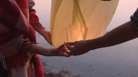 Sky lantern is launched by young couple at sunset Stock Footage 98920502