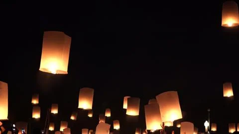 Sky lanterns floating at night in the dark sky Stock Photos