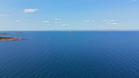 Sky meets water at a distant horizon with a large ship navigating across the Stock Footage 345472511