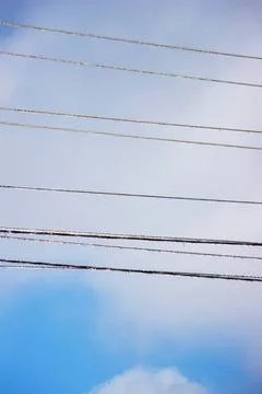 Sky with power lines and clouds on a bright day Stock Photos