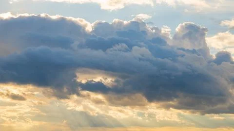Sky with rain clouds at sunset with rays of light Stock Photos