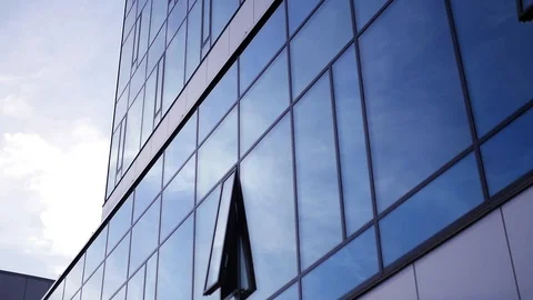 The sky is reflected in the facade of a glass office building. slow motion Stock Footage 97491218