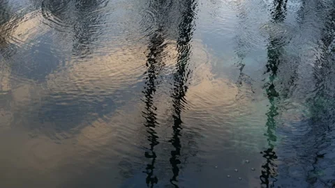 The sky is reflected on the surface of a natural lake and the water is bubbling. Stock Footage 230287395