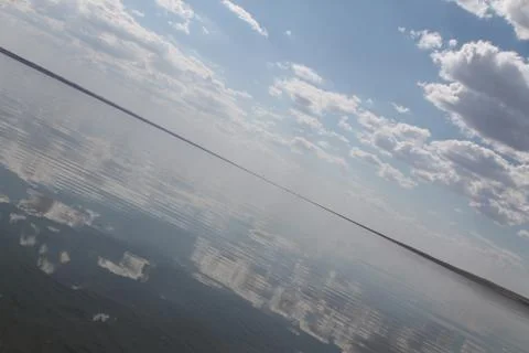 The sky reflected in the water, deserted beach lake, summer sky, nature, blue Stock Photos