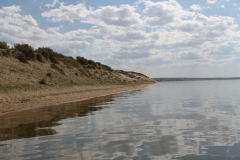 The sky reflected in the water, deserted beach lake, summer sky, nature, blue Stock Photos