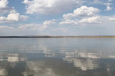 The sky reflected in the water, deserted beach lake, summer sky, nature, blue Stock Photos