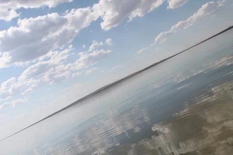 The sky reflected in the water, deserted beach lake, summer sky, nature, blue Stock Photos