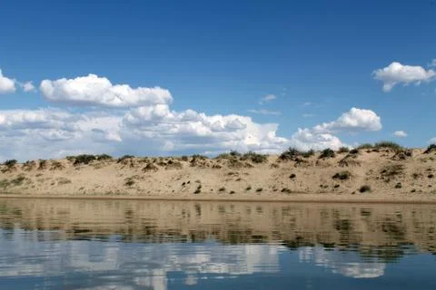 The sky reflected in the water, deserted beach lake, summer sky, nature, blue Stock Photos