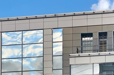 Sky reflection with clouds on the windows of the building. Stock Photos