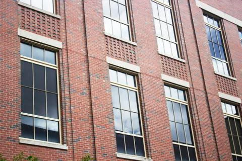 Sky reflection in glass window of brick structure Stock Photos