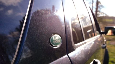 Sky Reflections: Close-Up of Land Rover Badge in Countryside Setting Stock Footage 269572537