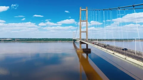 Sky reflects on calm water beneath a grand suspension bridge Stock-Footage 343528451