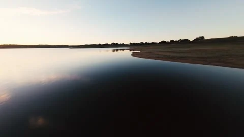 Sky reflects softly on calm water's surface at Pego do Altar Reservoir Stock Footage 342162320