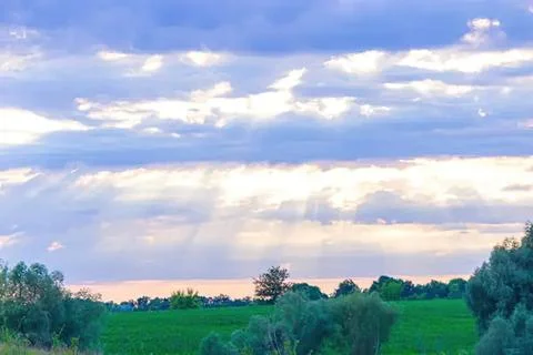 Sky with scattered clouds over green landscape Stock Photos