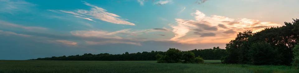 Sky at sunset with dark clouds, panoramic large shot. Background from the c.. Stock Photos