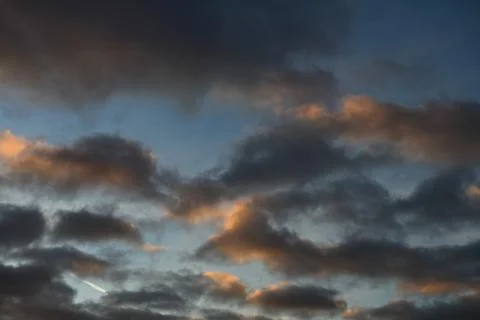 Sky texture with dark clouds at sunset Stock Photos