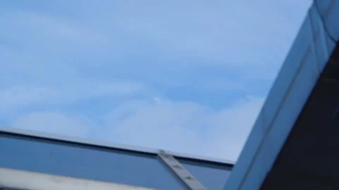 The sky through the roof with thin clouds and looming moon, daytime Stock Footage 295924500