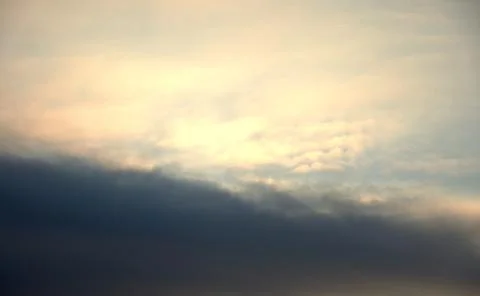 The sky, thunder clouds are illuminated from the rays of the rising sun. The Stock Photos