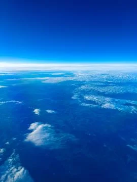 Sky view over clouds and earth from high altitude during daylight Stock Photos
