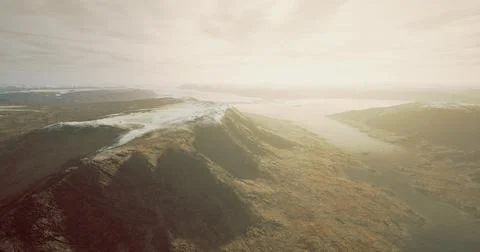 Sky view over rugged mountains and winding river in early morning light Ilustração Stock