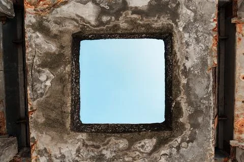 Sky Viewed Through Aged Square Window Opening in Ruined Concrete Wall With .. Fotos Stock