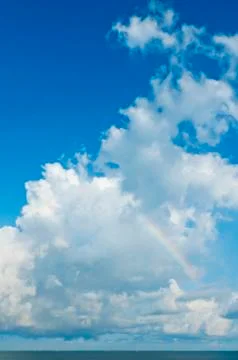 Sky, white clouds and rainbow Stock Photos