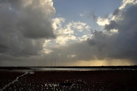 Sky with wild clouds reflected on them by the sun Stock Photos