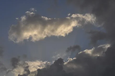 Sky with wild clouds reflected on them by the sun Stock Photos